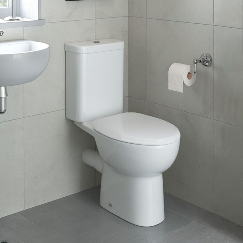 Close coupled toilet with soft-close seat in a modern tiled cloakroom featuring compact basin and wall-mounted toilet roll holder.